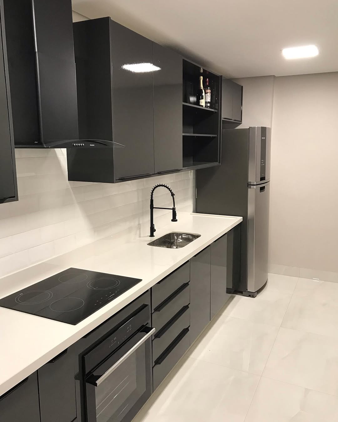 Cozinha Create com armários grafite, bancada clara e iluminação embutida